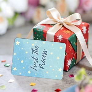 Détail d'une carte inspirante bleue avec Trust The Process près d'un coffret cadeau