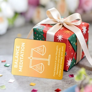 Close-up of golden balance meditation cards in a red Christmas gift box with silk ribbon