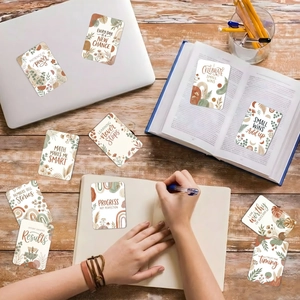 Détail de 18 cartes d'affirmation boho avec motifs floraux sur un bureau en bois