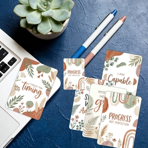 Lot de 18 cartes d'affirmation boho avec motifs botaniques et citations sur un bureau