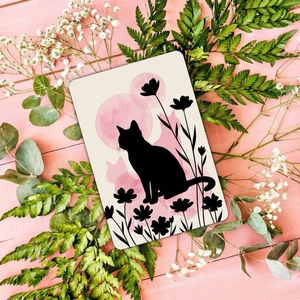 Artistic cat silhouette card with pink moon and floral details on a wood background