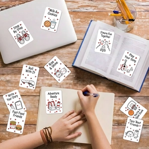 Detailed view of creative cartoon cards placed on a desk with a laptop and books