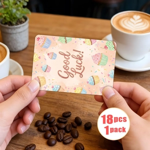 Dettaglio di un biglietto Good Luck con illustrazioni di cupcake colorati su un tavolo di legno