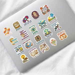 Bible verse stickers on a silver laptop with various Christian religious icons and motifs