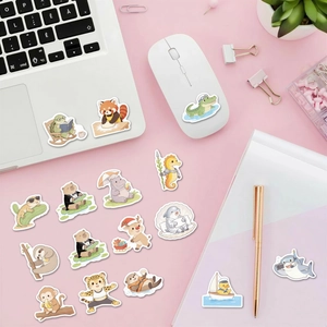 Flat lay με χαριτωμένα αυτοκόλλητα ζώων σε ροζ γραφείο με λευκό laptop και διακόσμηση