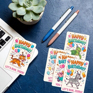 Detailed view of colorful cartoon animal birthday cards on a desktop with stationery
