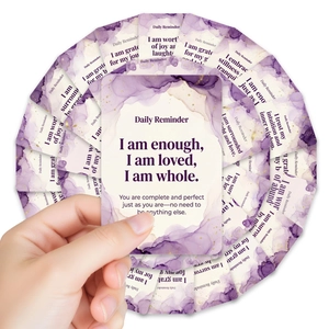 Close-up of violet watercolor affirmation cards with gold accents held by a hand