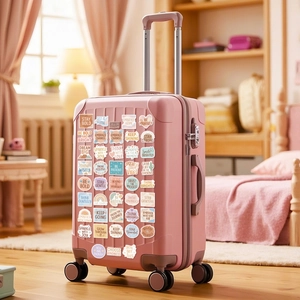 Dettaglio di adesivi boho ispiratori in colori pastello su una valigia rosa decorata