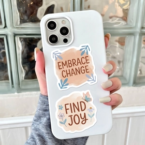 Dettaglio custodia iPhone bianca con citazioni motivazionali Embrace Change e Find Joy