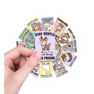 Nahaufnahme einer Hand, die eine süße Cartoon-Tier-Motivationskarte zur Deko hält