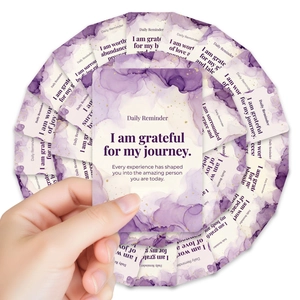 Macro view of watercolor daily reminder cards with golden glitter and positive quotes