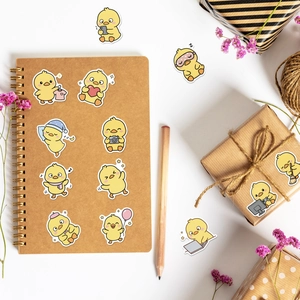 Simpatici adesivi con papera gialla che decorano un taccuino e una confezione regalo