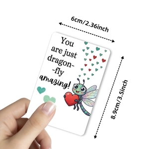 Positive dragonfly greeting card with dimensions 8.9x6cm shown in hand for scale