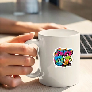 Nahaufnahme einer weißen Tasse mit buntem 67 Graffiti-Sticker in menschlichen Händen