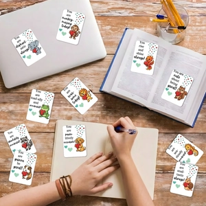 Close-up of animal pun motivational cards on a wooden desk with a laptop and pen