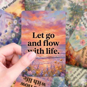 Close-up of Monet style card with sunset scenery and Let go and flow with life quote