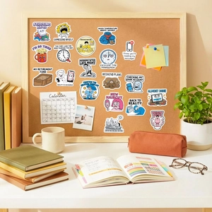 Creative humorous vinyl stickers shown on cork board in a cozy home office setup