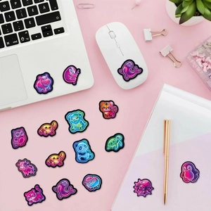 Neon cartoon animal stickers decorating a laptop and mouse on a clean pink desk