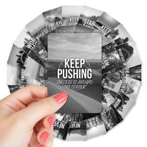 Close-up of hand holding black and white inspirational quote cards with scenery background