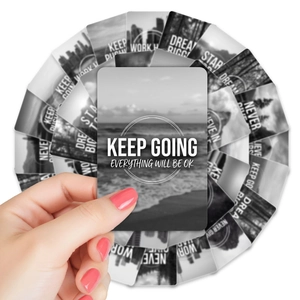 Detail of hand holding a black landscape card from a 36-piece motivational set