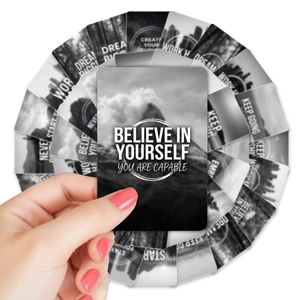 Close-up of hand holding black inspirational affirmation cards with motivational quotes