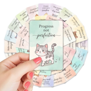 Close-up of watercolor cat affirmation cards featuring Progress Not Perfection text