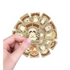 Close-up of hand-held cartoon animal motivational cards with orange artistic typography