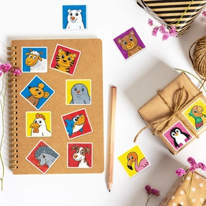 Close-up of 12 cute crayon-style animal stickers for scrapbooking on a clean desk