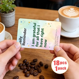 Close-up of 18 motivational quote cards with watercolor design held by hands in a cafe
