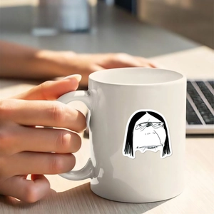 Dettaglio di una tazza in ceramica bianca con illustrazioni umoristiche in un ufficio