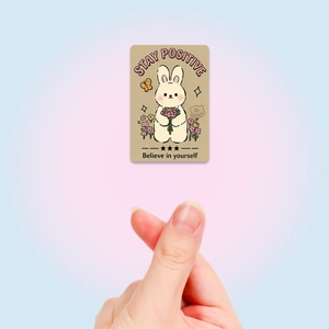 Close-up of a cartoon rabbit card with Stay Positive and Believe in yourself text