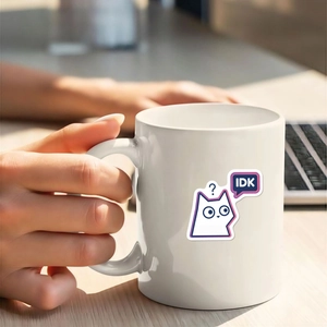 Nahaufnahme einer Keramiktasse mit minimalistischer weißer Katze und IDK Textdesign