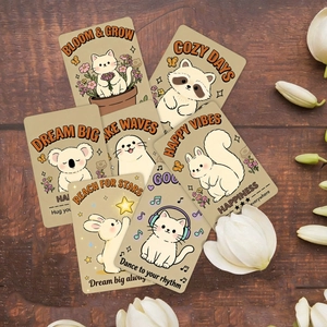 Close-up of cute cartoon animal motivation cards arranged on a dark wooden table surface