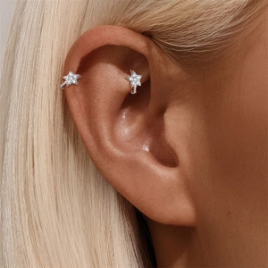 Détail de boucles d'oreilles cartilage en argent avec étoiles en moissanite sur l'oreille