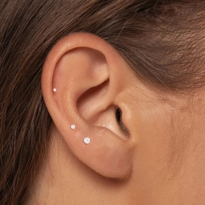 Close-up of S925 silver screw back stud earrings with sparkling moissanite on ear
