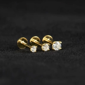 Macro detail of three 16G s925 silver screw back stud earrings with sparkling moissanite gems
