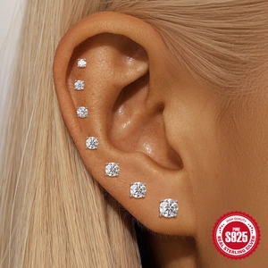Set of 7 S925 sterling silver moissanite stud earrings in graduated sizes on ear