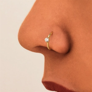 Close-up of a gold s925 silver nose ring featuring a brilliant four-prong set cubic zirconia