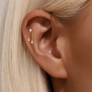 Macro-opname van s925 gouden ster kraakbeen piercing met bungelende zirkonia kettingen