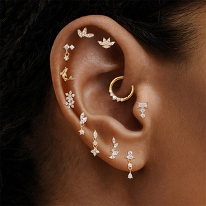 Close-up of golden multi-piece earring set with butterfly and zircon charms on model