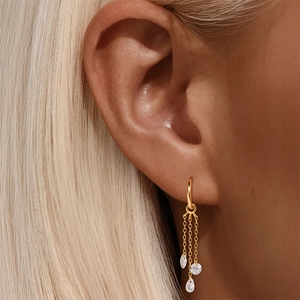 Detailed view of 18K gold hoop earrings with cascading tassels and pear-cut white zircons