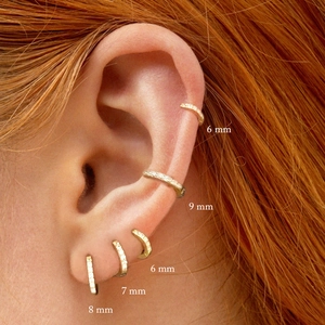Close-up of gold 925 sterling silver hoop earrings set with sparkling zircon stones