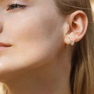 Primer plano de ear cuffs de plata de ley S925 pulida multicapa y ondulados en modelo