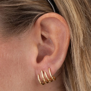 Vista detallada de pendientes dorados en forma de C con diseño de cuatro filas apiladas
