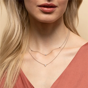 Close-up of double-layer S925 silver necklace with round and heart cubic zirconia pendants