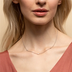 Close-up of minimalist S925 sterling silver chain with three sparkling round diamonds