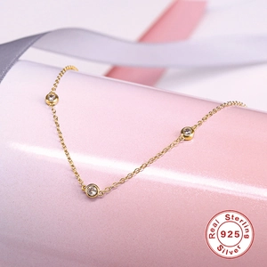 Detailed macro of gold plated S925 silver necklace featuring three sparkling zircons