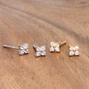 Macro shot of S925 silver flower stud earrings with sparkling zircon petals and metal posts