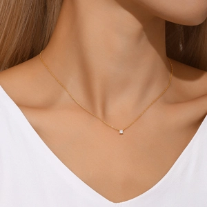 Primer plano de un collar minimalista de plata S925 dorada con colgante de circón