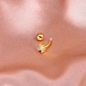 Macro view of gold S925 silver curved barbell stud with three clear zircon stones